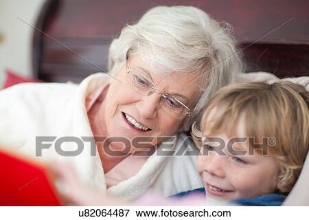 Grandmother and grandson reading storybook in bed View Large Photo Image Stock Photo - Grandmother and grandson reading storybook in bed. Fotosearch