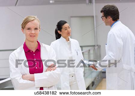 Stock Image - Group of scientists in laboratory atrium. Fotosearch