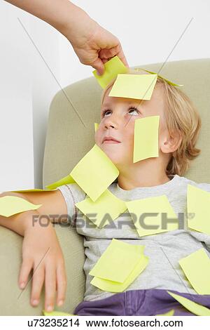 Hand sticking adhesive notes on boy View Large Photo Image Picture - Hand sticking adhesive notes on boy. Fotosearch