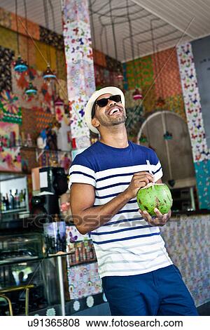 Happy man with coconut drink View Large Photo Image Stock Photo - Happy man with coconut drink. Fotosearch