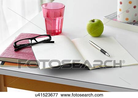 Stock Photo - Kitchen table still life with notebooks, spectacles and apple. Fotosearch