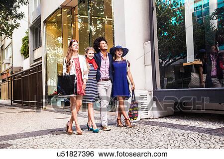 Stock Photograph - Male and female friends on shopping trip. Fotosearch