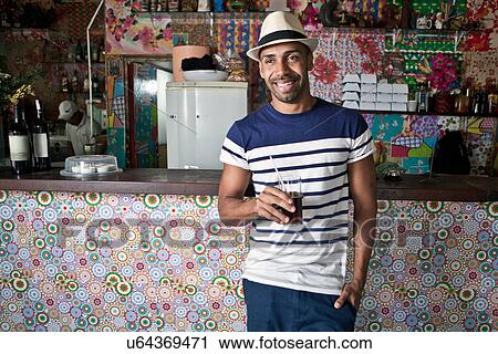 Man by counter of cafe bar with a drink View Large Photo Image Stock Image - Man by counter of cafe bar with a drink. Fotosearch