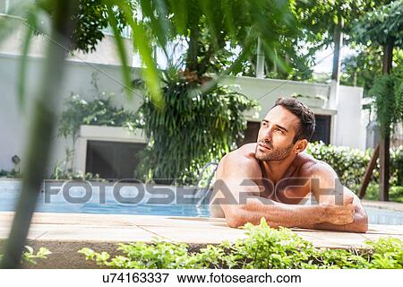 Man leaning on poolside, looking away View Large Photo Image Stock Photo - Man leaning on poolside, looking away. Fotosearch