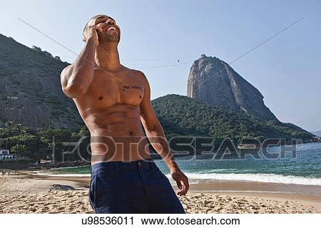 Man on beach using cell phone, Rio de Janeiro, Brazil View Large Photo Image Stock Image - Man on beach using cell phone, Rio de Janeiro, Brazil. Fotosearch