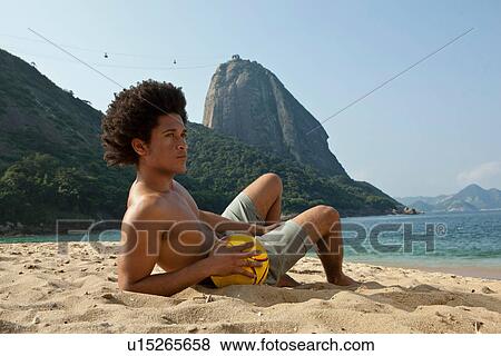 Stock Photo - Man on beach with volleyball, Rio de Janeiro, Brazil. Fotosearch