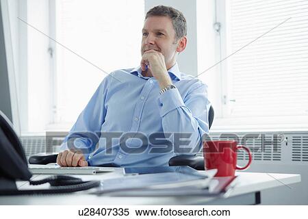 Stock Photography - Man sitting at his desk. Fotosearch