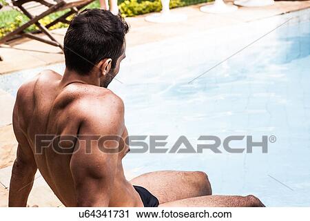 Man sitting at poolside View Large Photo Image Stock Image - Man sitting at poolside. Fotosearch