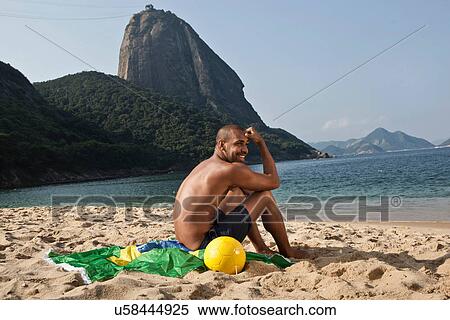Man sitting on beach, Rio de Janeiro, Brazil View Large Photo Image Stock Photography - Man sitting on beach, Rio de Janeiro, Brazil. Fotosearch