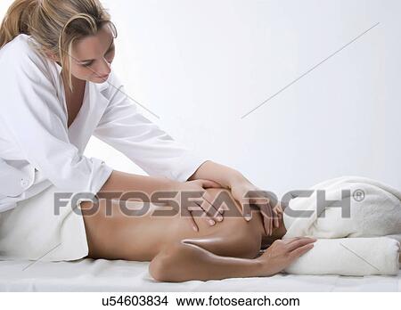 Masseuse massaging woman's shoulder View Large Photo Image Picture - Masseuse massaging woman's shoulder. Fotosearch