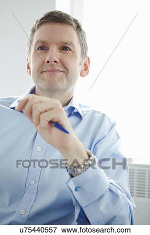 Mature businessman holding pen View Large Photo Image Stock Photo - Mature businessman holding pen. Fotosearch