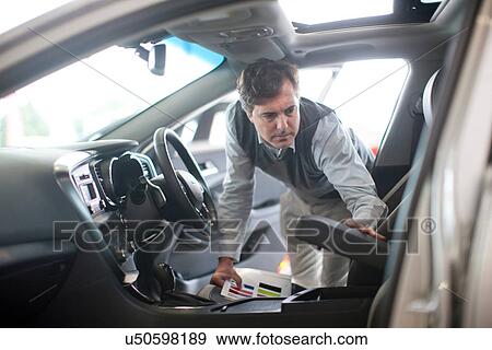 Mid adult man checking arm rest in car showroom View Large Photo Image Stock Photo - Mid adult man checking arm rest in car showroom. Fotosearch