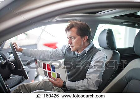 Mid adult man checking dashboard in car showroom View Large Photo Image Stock Photograph - Mid adult man checking dashboard in car showroom. Fotosearch