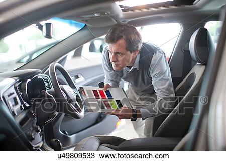 Mid adult man with color swatch in car showroom View Large Photo Image Stock Image - Mid adult man with color swatch in car showroom. Fotosearch