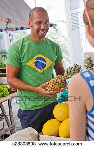 Stock Photo - Mid adult man with pineapple. Fotosearch