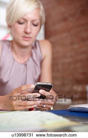 Mid adult woman using smartphone View Large Photo Image Stock Image - Mid adult woman using smartphone. Fotosearch