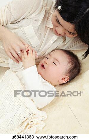 Mother and baby boy lying together holding hands View Large Photo Image Stock Image - Mother and baby boy lying together holding hands. Fotosearch