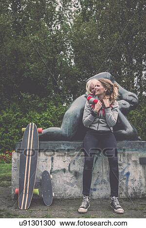 Stock Image - Mother and daughter in front of park sculpture with skateboards. Fotosearch