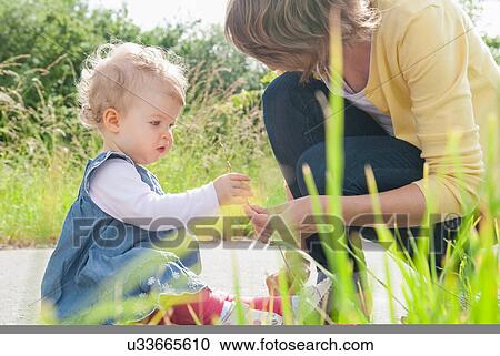 Mother and daughter looking at grass View Large Photo Image Stock Image - Mother and daughter looking at grass. Fotosearch