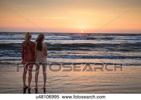 Stock Photography - Mother and daughter looking at sunset. Fotosearch