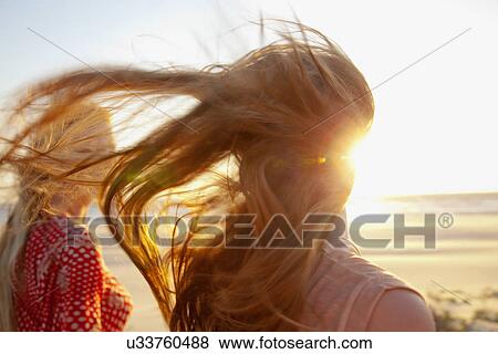 Stock Photo - Mother and daughter on windy beach, close up. Fotosearch