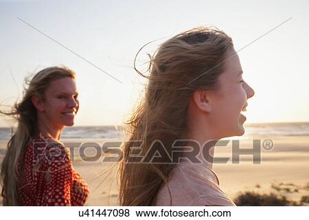 Stock Photo - Mother and daughter on windy beach, close up. Fotosearch