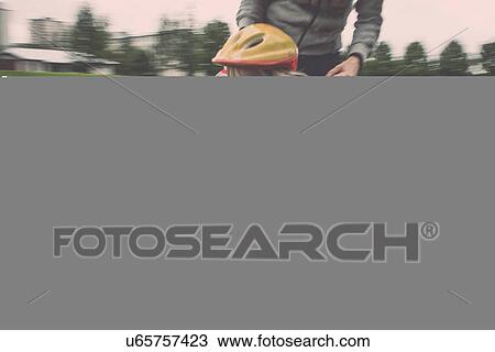 Stock Image - Mother and daughter riding on skateboard in park. Fotosearch