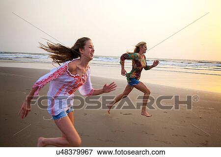 Mother and daughter running on beach View Large Photo Image Stock Photo - Mother and daughter running on beach. Fotosearch
