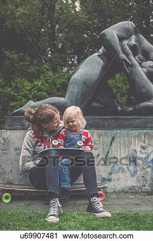 Mother and daughter sitting in front of park sculpture with skateboards View Large Photo Image Stock Image - Mother and daughter sitting in front of park sculpture with skateboards. Fotosearch