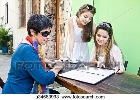 Mother and daughters at cafe together View Large Photo Image Stock Image - Mother and daughters at cafe together. Fotosearch