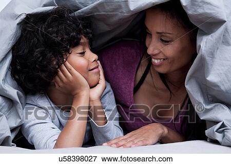 Mother and son hiding underneath the duvet View Large Photo Image Stock Photo - Mother and son hiding underneath the duvet. Fotosearch