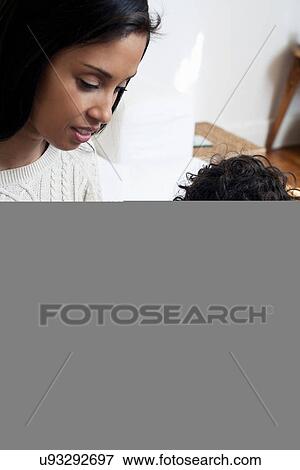 Mother and son looking at book View Large Photo Image Stock Photo - Mother and son looking at book. Fotosearch