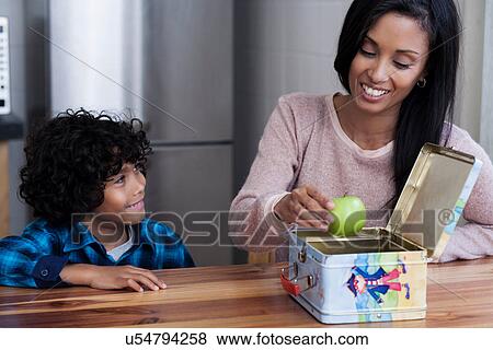 Stock Photo - Mother and son packing lunch box. Fotosearch