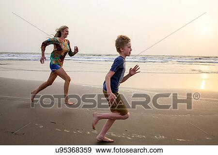 Stock Photo - Mother and son running on beach. Fotosearch
