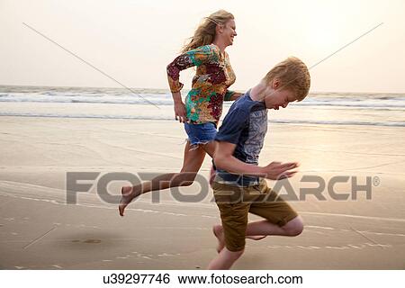 Mother and son running on beach View Large Photo Image Stock Photograph - Mother and son running on beach. Fotosearch