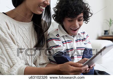 Stock Photograph - Mother and son using digital tablet. Fotosearch