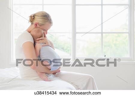 Picture - Mother cradling baby boy. Fotosearch