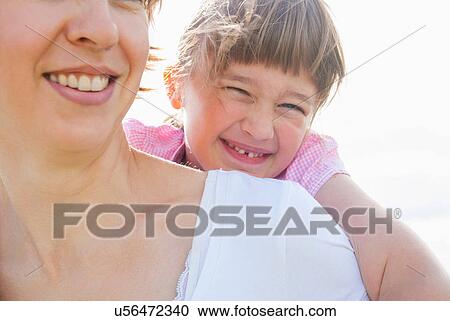 Mother giving daughter piggy back View Large Photo Image Stock Image - Mother giving daughter piggy back. Fotosearch