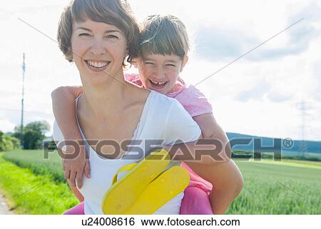 Mother giving piggyback to daughter View Large Photo Image Stock Photograph - Mother giving piggyback to daughter. Fotosearch