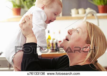 Stock Photograph - Mother holding baby mid air. Fotosearch