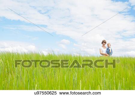 Mother holding daughter in field View Large Photo Image Stock Photography - Mother holding daughter in field. Fotosearch