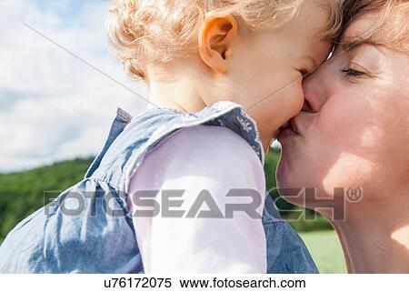 Stock Photography - Mother kissing daughter. Fotosearch