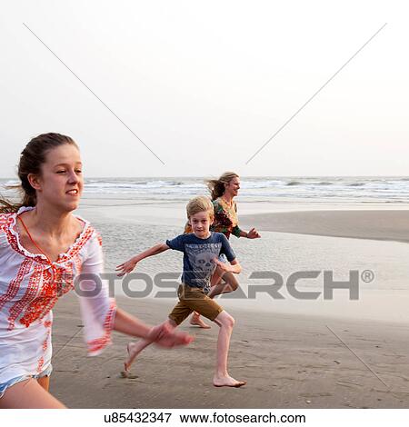 Mother, son and daughter running on beach View Large Photo Image Stock Photo - Mother, son and daughter running on beach. Fotosearch