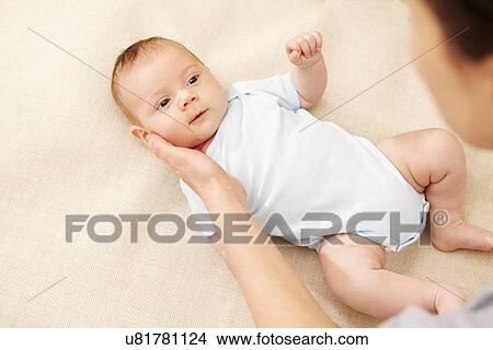 Mother touching baby boy's cheek View Large Photo Image Picture - Mother touching baby boy's cheek. Fotosearch