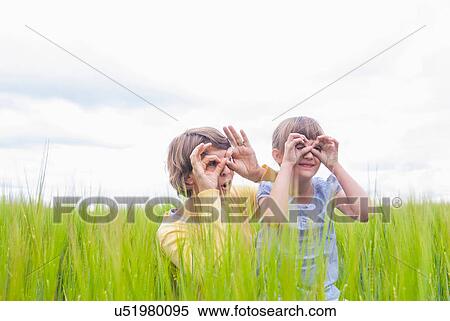 Stock Photography - Mother with daughter making pretend binoculars with hands. Fotosearch