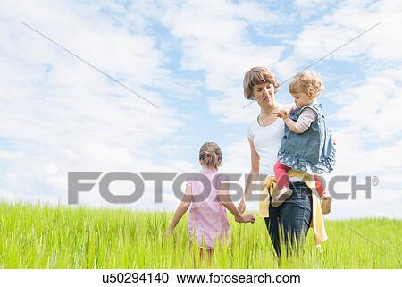 Mother with two daughters in field View Large Photo Image Stock Image - Mother with two daughters in field. Fotosearch