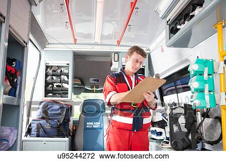 Paramedic in ambulance listing equipment View Large Photo Image Stock Image - Paramedic in ambulance listing equipment. Fotosearch