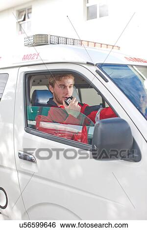 Stock Photograph - Paramedic in ambulance on walkie-talkie. Fotosearch