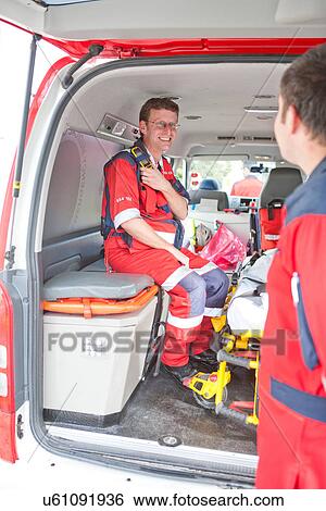 Paramedic in ambulance waiting for call View Large Photo Image Stock Photograph - Paramedic in ambulance waiting for call. Fotosearch