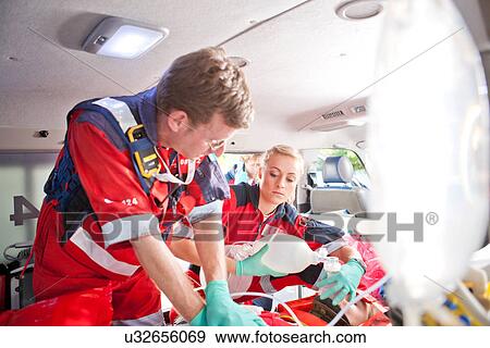 Paramedics giving patient heart massage in ambulance View Large Photo Image Stock Photo - Paramedics giving patient heart massage in ambulance. Fotosearch
